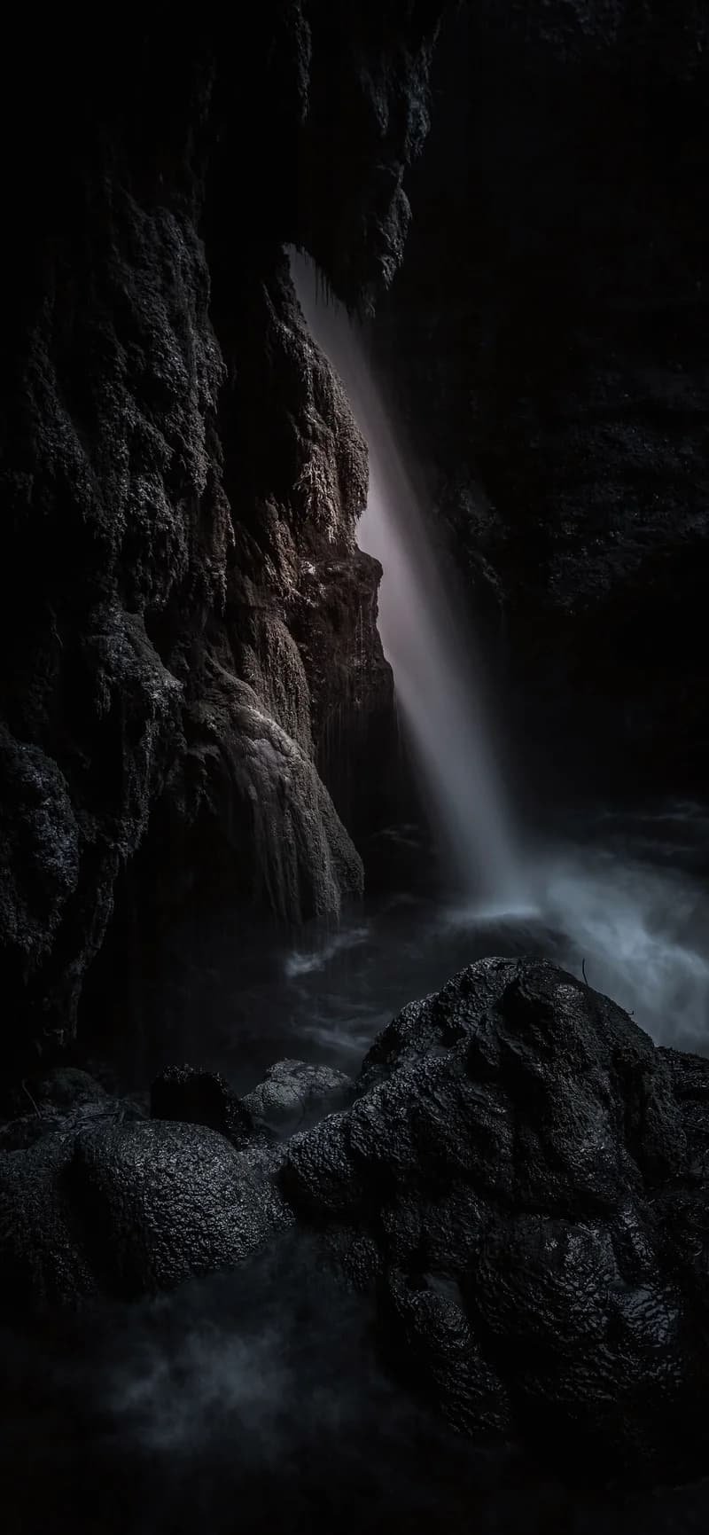 Mystical Subterranean Waterfall Cascading in Shadow 4K Nature Wallpaper